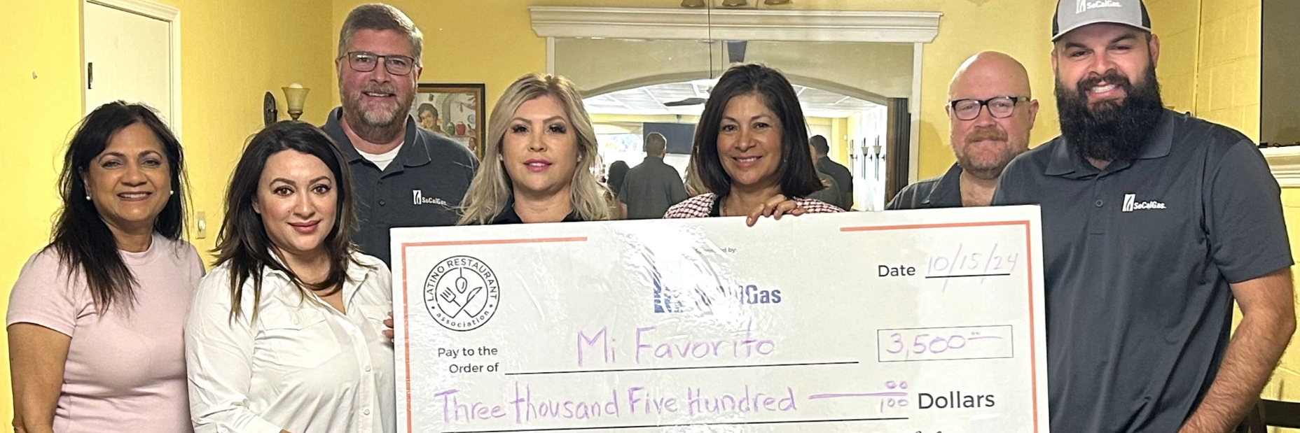 7 people holding a 3,5000 dollar check from the Latino Restaurant Association at Mi Favorito
