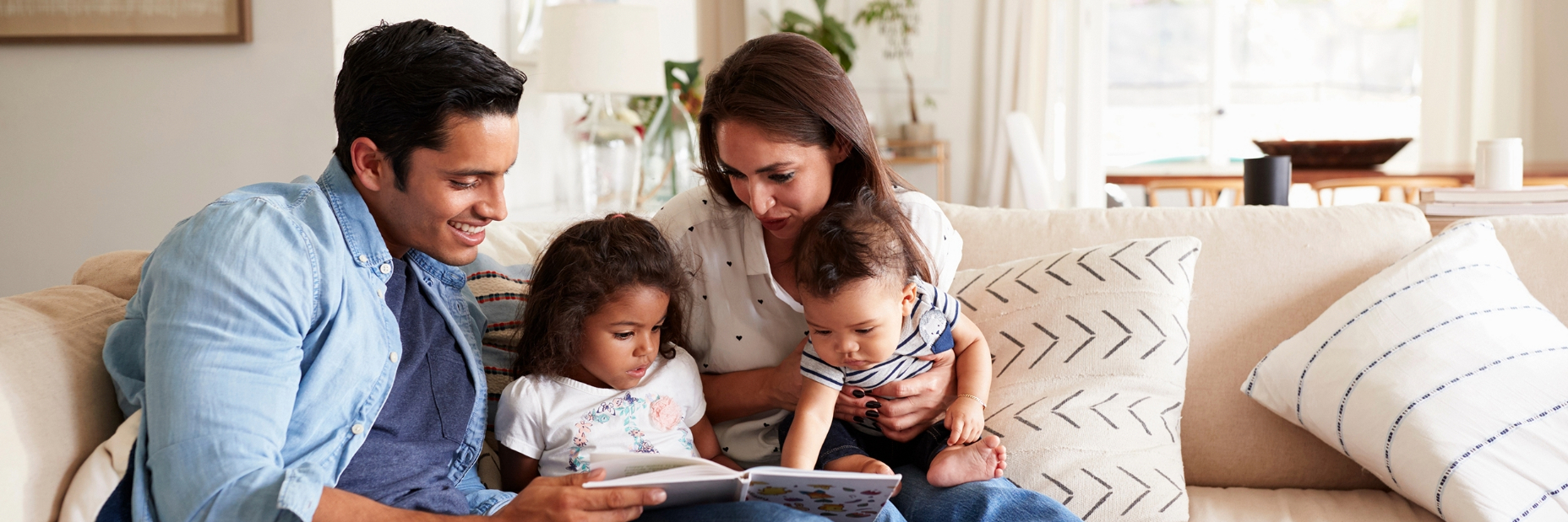 Family on the couch reading a book together