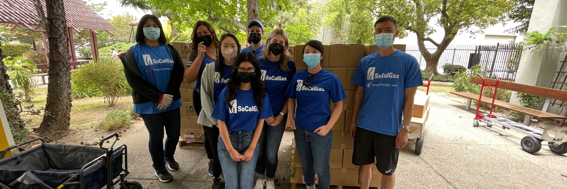 Volunteers posing for a photo as they distribute groceries