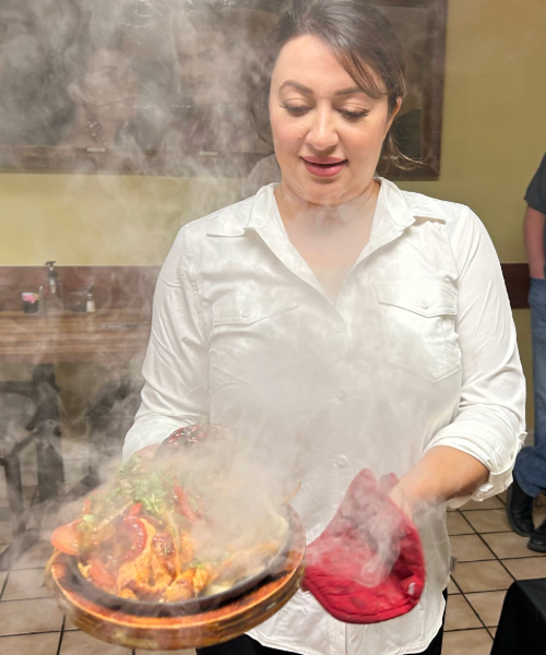 Restaurant owner holding a sizzling fajita plate