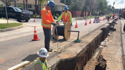 workers laying cable in a trench