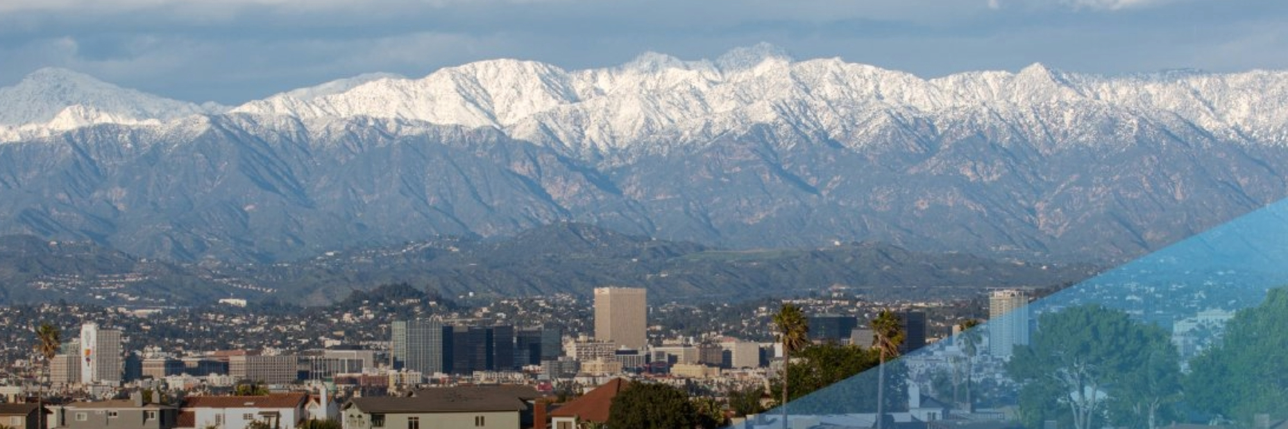 Mountains with snow in background, city in foreground 1856x619