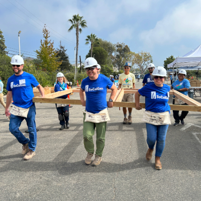 SoCalGas employees carrying prefab framing