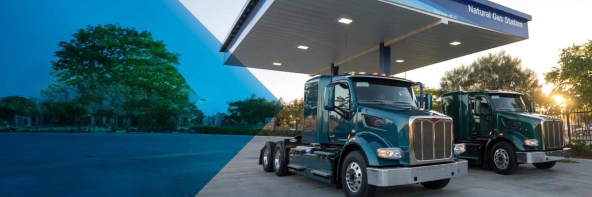 two natural gas trucks sitting at a filling station