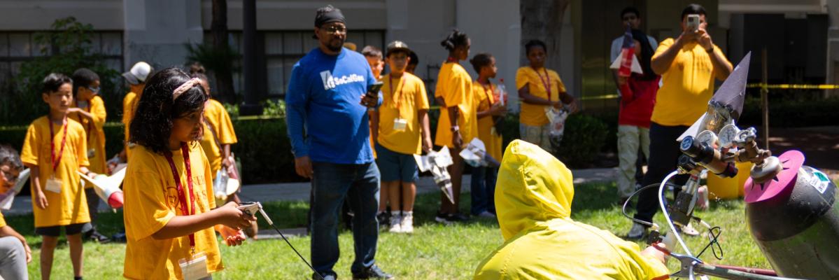 Students shooting off @ liter bottles shaped like rockets at the quad on the campus of USC.