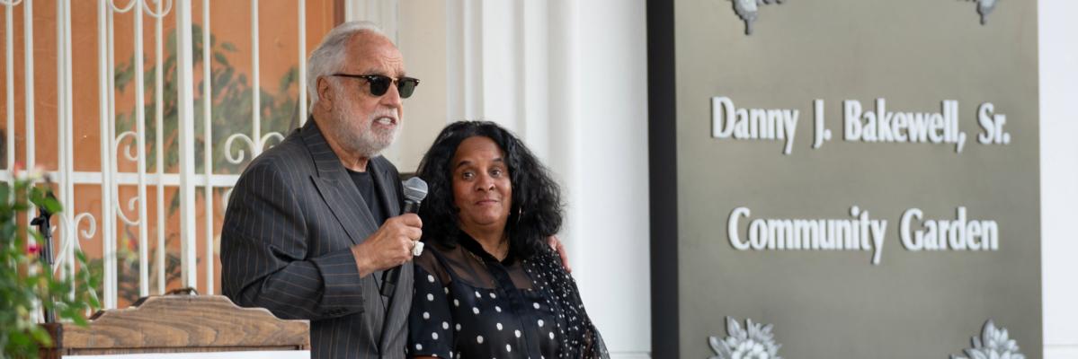 Man and woman speaking on microphone.