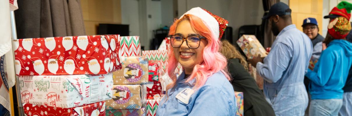 SoCalGas employee bringing present into a toy drive and placing them on a table.
