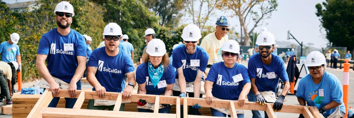 SoCalGas volunteers lifting a framing to a wall on a house