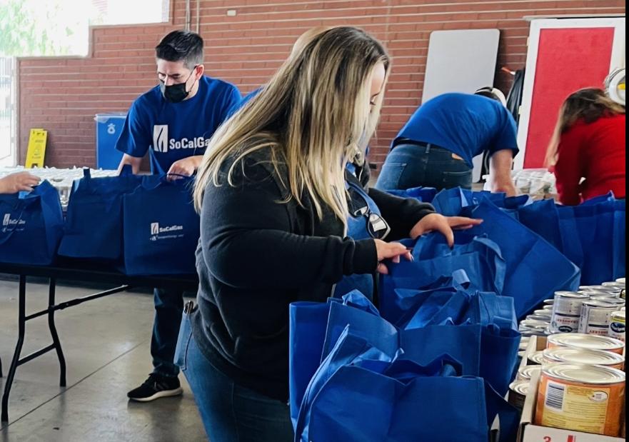 SoCalGas volunteers putting together bags with thanksgiving items