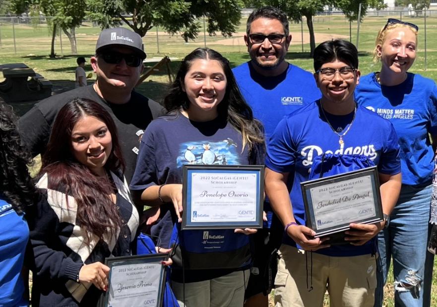 Students holding their scholarship awards with socalgas employees