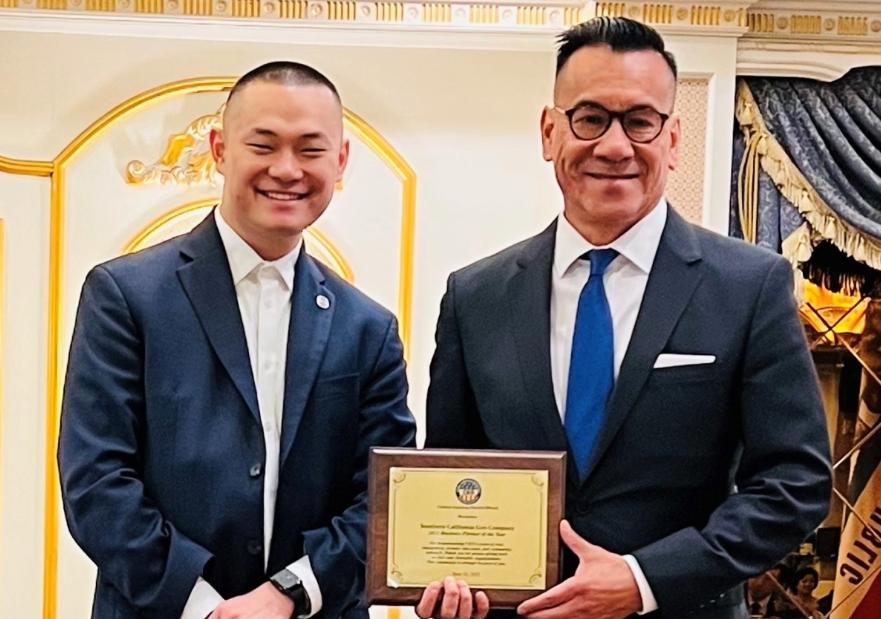 Two men holding the award