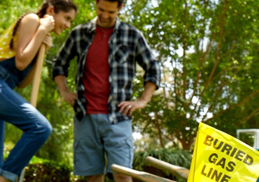 Man and woman digging with buried gas lines marked from calling 811