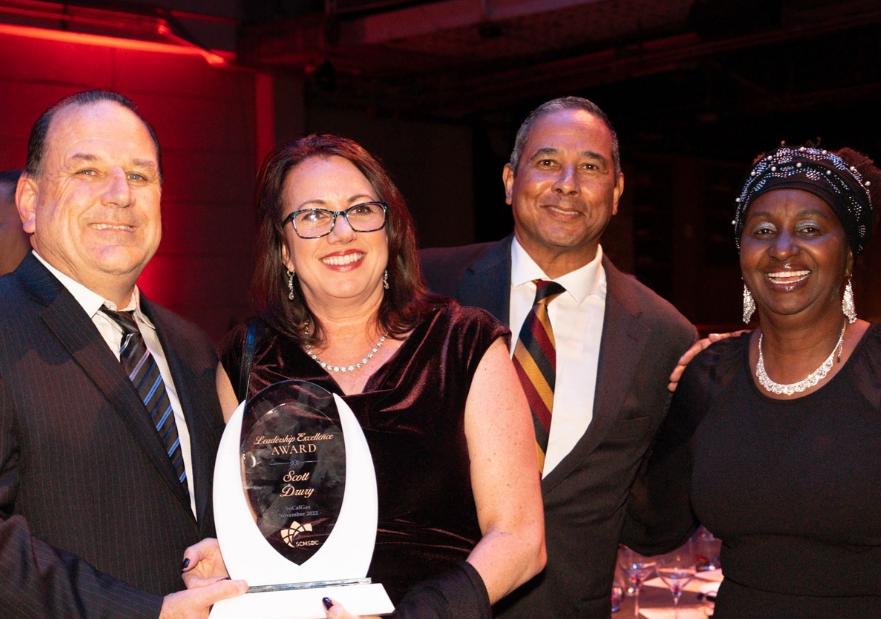 Scott holding award with group of people