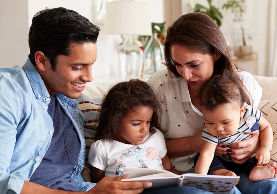 Family on the couch reading a book together
