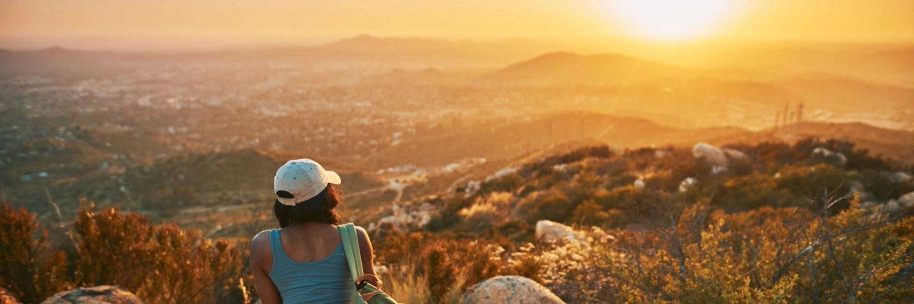 Woman Overlooking Sunny Mountains
