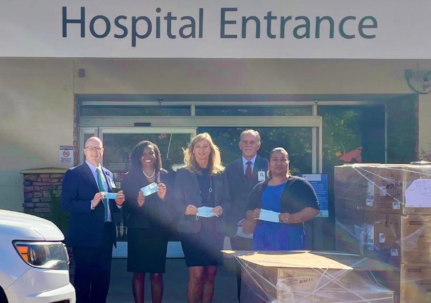 people outside of hospital entrance with delivery of masks