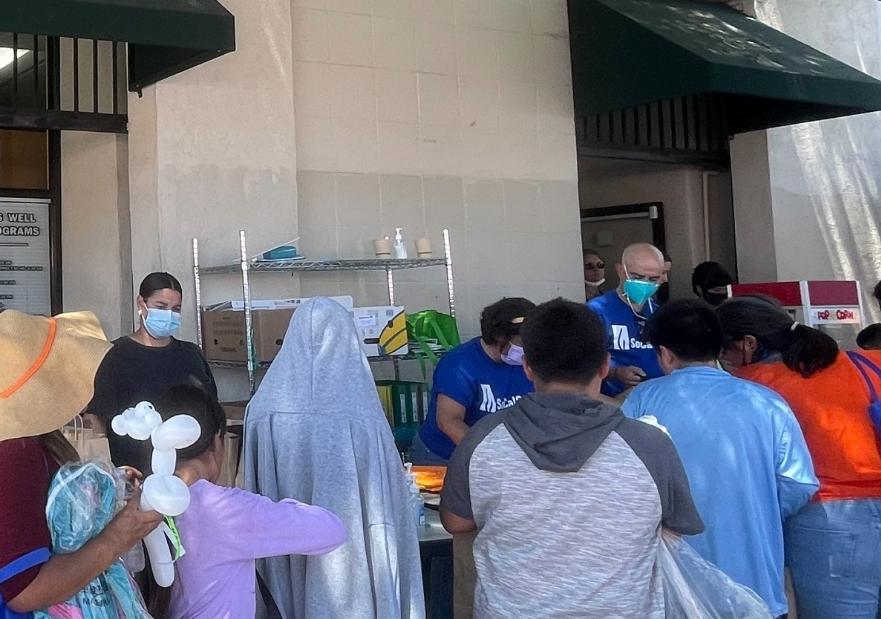 People getting school supplies outside an office building