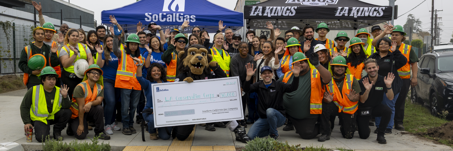 Large group of volunteers holding a check