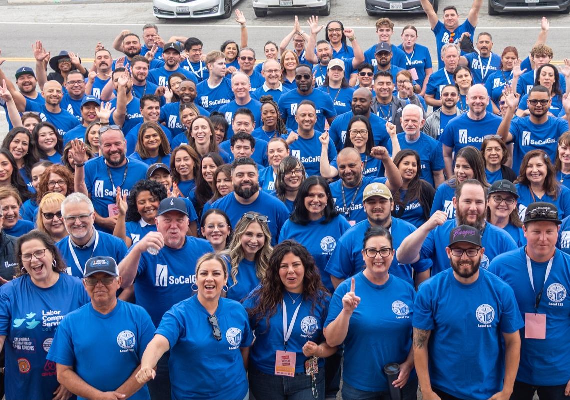 Dozens of socalgas employees posing for a photo at a food sorting facility.